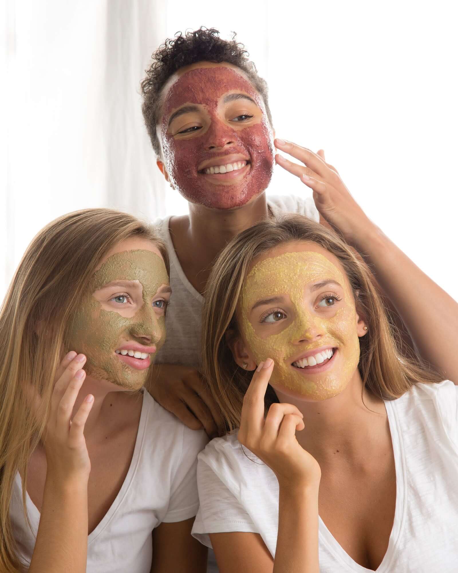 three women putting on skincare face masks together