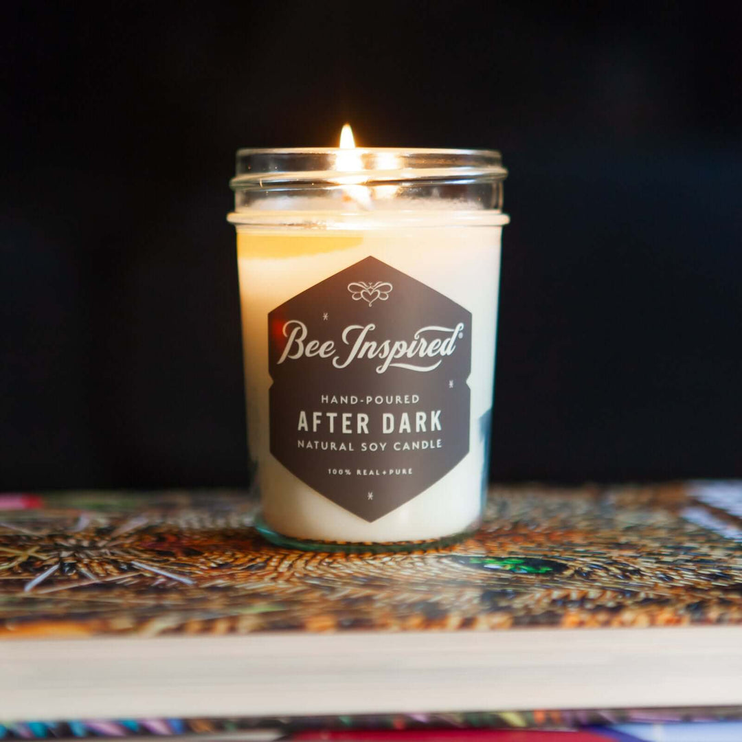 After Dark jelly jar candle burning on stack of books 