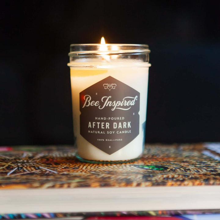 After Dark jelly jar candle burning on stack of books 