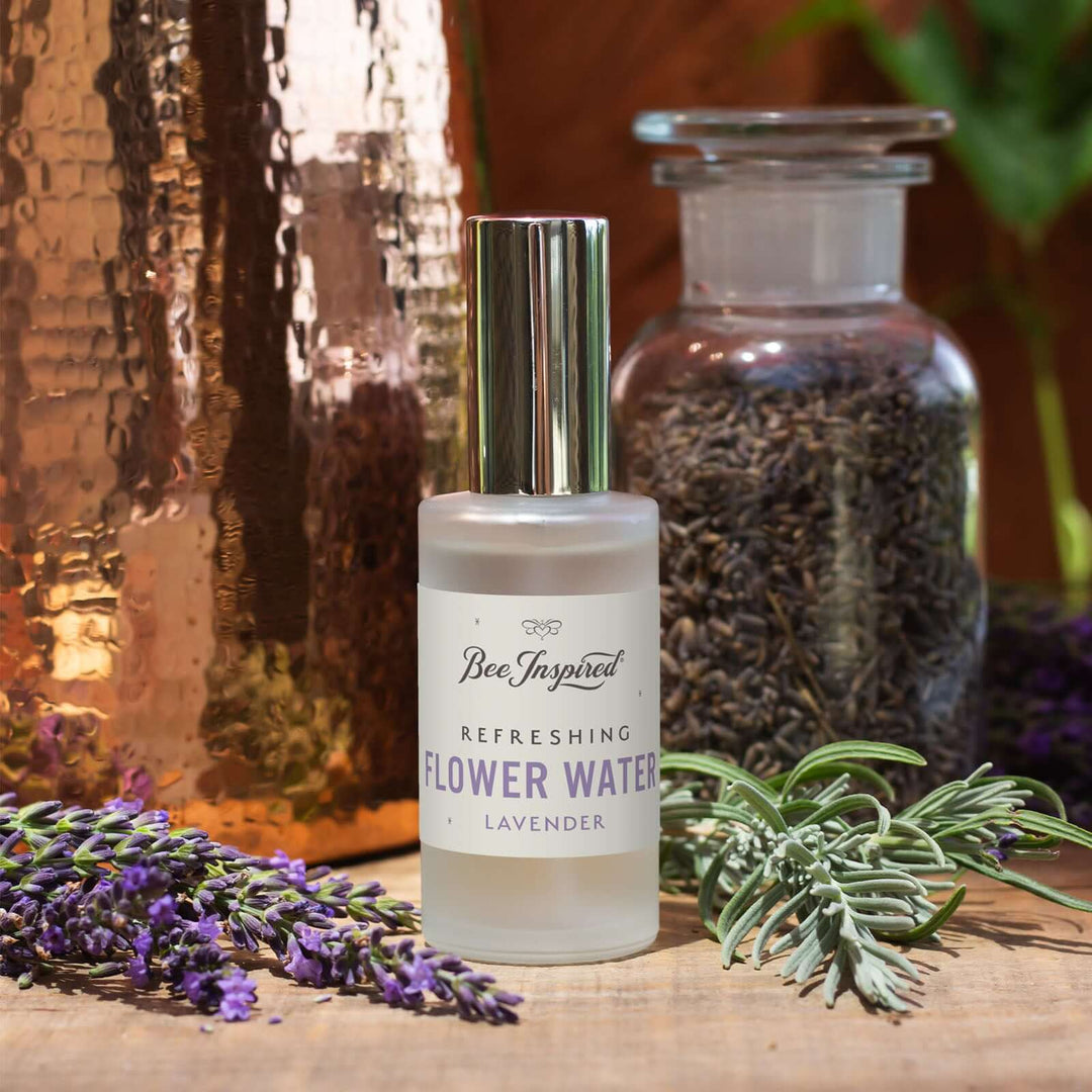Bee inspired lavender flower water next to fresh lavender and a jar of lavender buds 