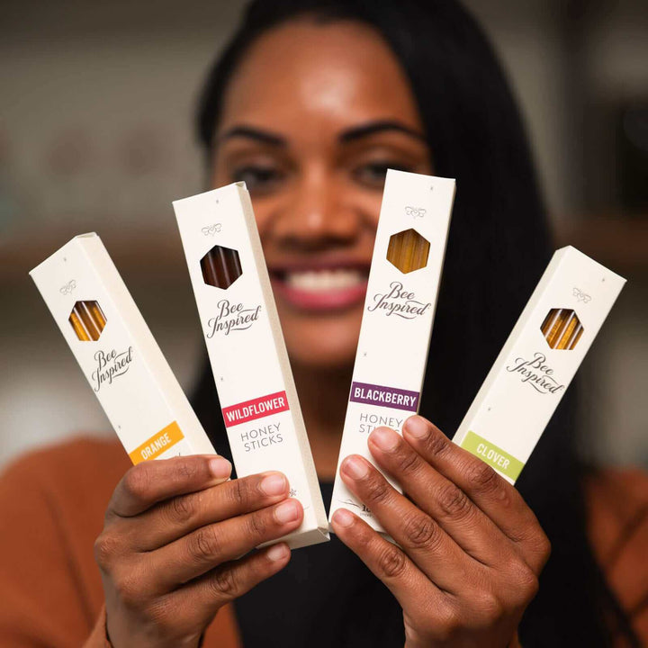 Woman holding boxes of varietal honey sticks 