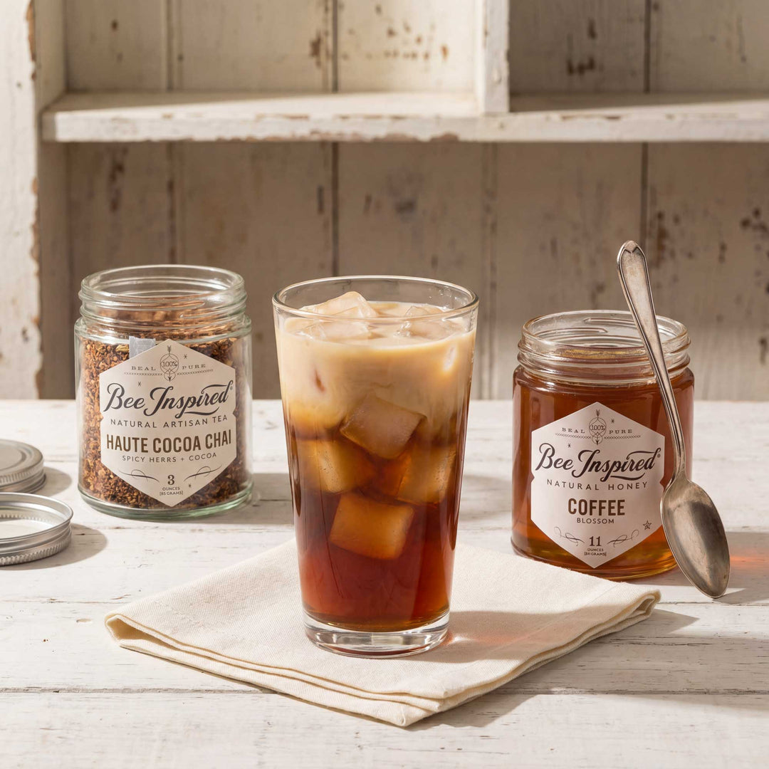 Iced coffee with Bee Inspired honey and cocoa mix on a rustic wooden table.
