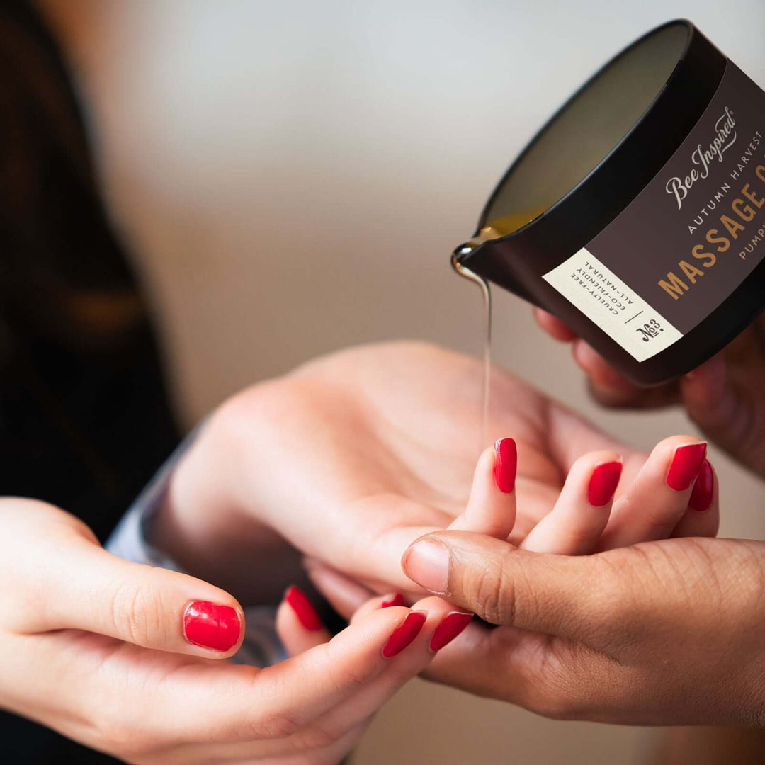 pouring oil of Autumn Harvest massage candle onto hands 