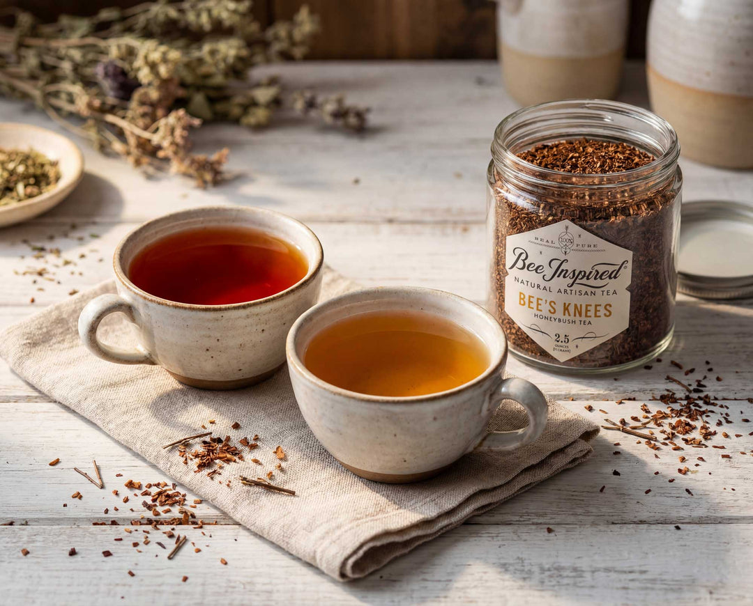 Two cups of tea with a jar labeled 'Bee's Knees' on a wooden surface.