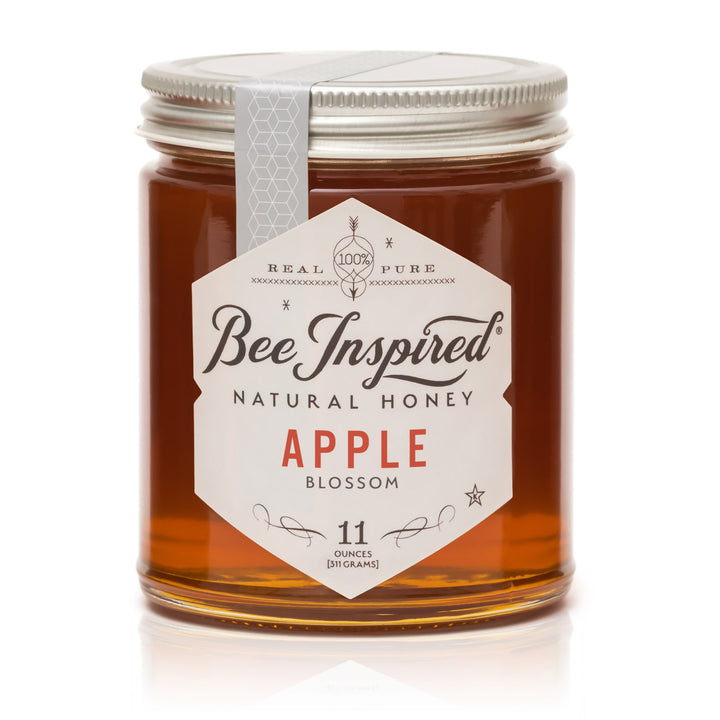Jar of Bee Inspired natural honey with a label on a white background
