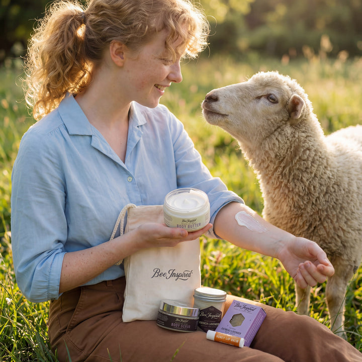 Woman applying cream to her arm with a sheep in a field, holding &
