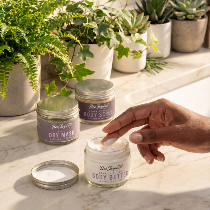 Hand interacting with a jar of body butter on a marble surface with plants in the background