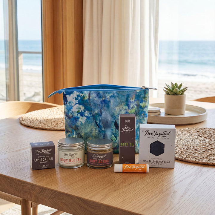 Collection of Bee Inspired products on a wooden table with a beach view in the background