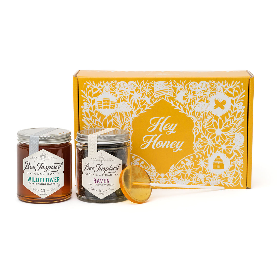 Two jars of honey with a decorative box labeled 'Hey Honey' on a white background