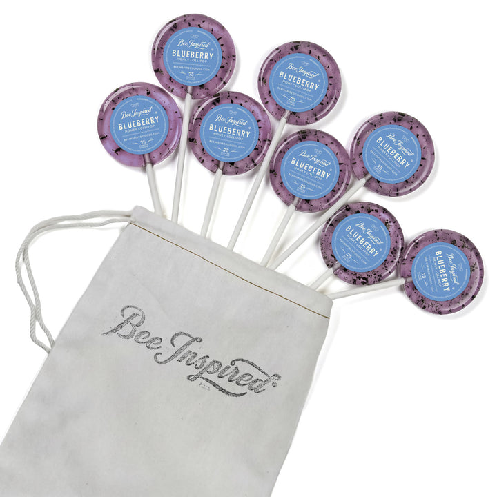 Purple lollipops with blue labels on sticks next to a &