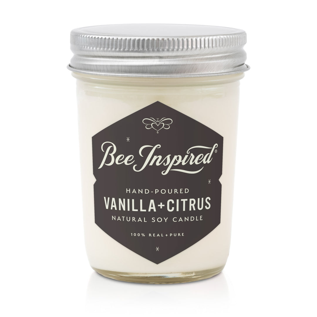 Candle jar labeled 'Bee Inspired Vanilla + Citrus' on a white background
