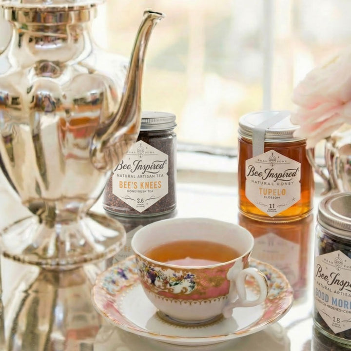 Tea cup with floral design on a saucer, surrounded by jars labeled &
