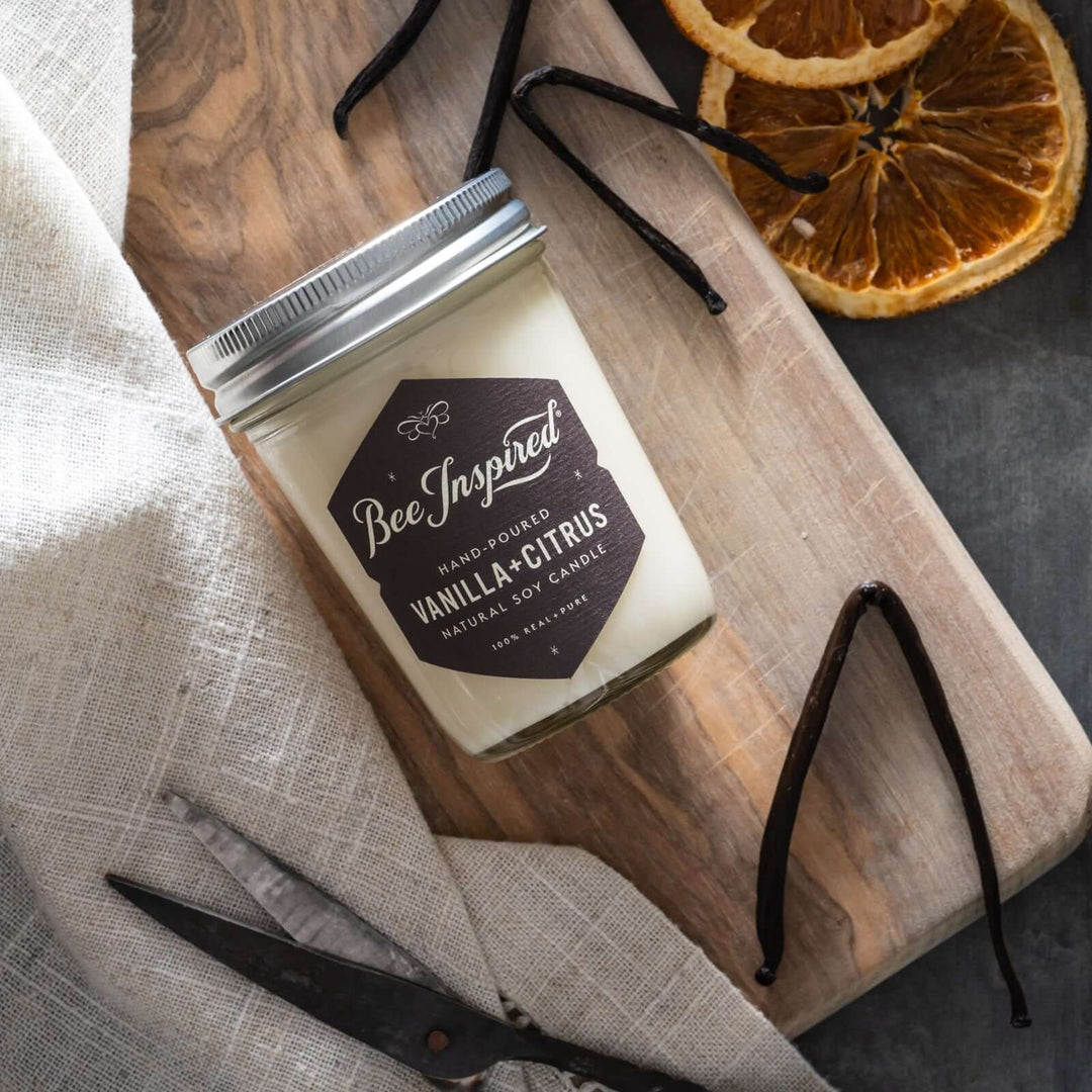 Vanilla Citrus jelly jar candle flat lay next to vanilla bean and dried oranges 